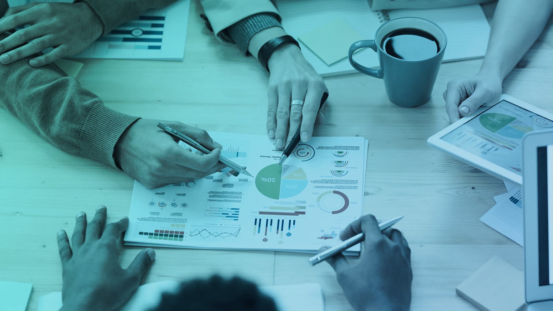 pessoas apontando para gráfico em papel com caneta