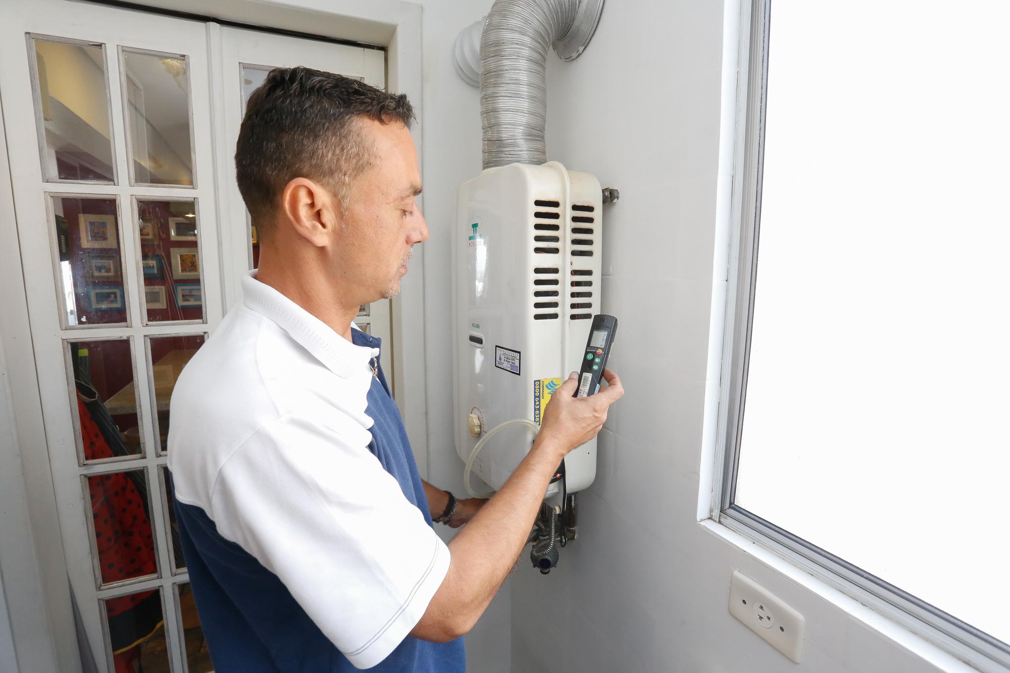 homem mexendo em central de gás residencial